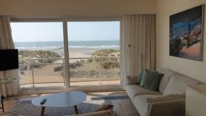 a living room with a couch and a view of the beach at Zeemeermin in Nieuwpoort