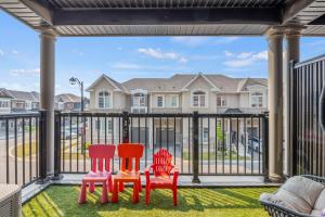 three chairs sitting on a balcony with a view of a house at Modern Family Friendly 4BR Home Away From Home in Milton