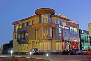 a large yellow building with a round top at Hotel Monopoli Kutaisi in Kutaisi