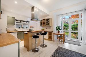 a kitchen with a sink and a counter with stools at Pass the Keys Gorgeous 4 Bed House - Sleeps 6 in Manchester