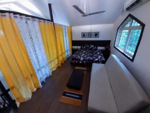 a bedroom with yellow curtains and a bed and a window at Voyager's Nest in Phanda