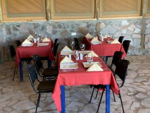 a group of tables with red table cloths at Resian Mara Camp in Talek