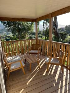 a porch with two chairs and a bench on it at Les collines de lava in Appietto