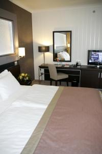 ブダペストにあるアクアワールド リゾート ブダペストのベッド、デスク、コンピュータが備わるホテルルームです。