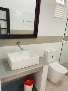 ein Bad mit einem Waschbecken und einem WC in der Unterkunft Sevenra Grand Beach Hotel in Ambalangoda
