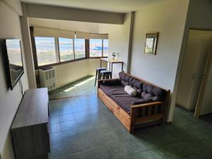 una sala de estar con sofá en una habitación con ventanas en Departamento Playa Grande Alem Golf en Mar del Plata