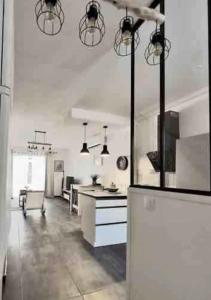 une grande cuisine blanche avec un comptoir et une table dans l'établissement *Secret Sand* Cheerfull Town beach house villa, à La Baie-Orientale