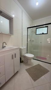 W łazience znajduje się toaleta, umywalka i prysznic. w obiekcie Casa Amor Perfeito com Jacuzzi- Próximo ao Parque Termal w mieście Piratuba