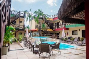 a pool with chairs and a table and a building at Apart Hotel Serantes in Natal