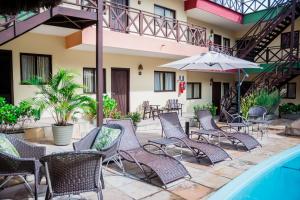 - un groupe de chaises et un parasol à côté de la piscine dans l'établissement Apart Hotel Serantes, à Natal