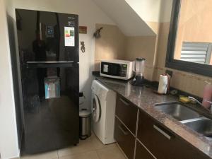 Una pequeña cocina con fregadero y microondas. en Pinos De Mar, en Costa del Este