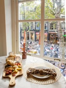 a table with a plate of food and a window at Georgia's Bathhouse in Breda