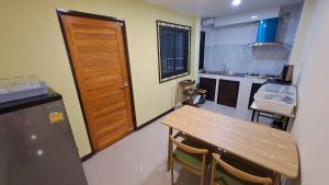 uma cozinha com uma mesa de madeira e uma porta de madeira em Hatyai.Muslim.Home em Hat Yai