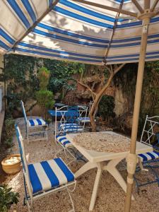 een patio met stoelen, een parasol en een tafel bij centre d'affaire in Zemmour Touirza