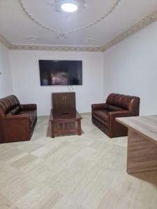een woonkamer met 2 leren banken en een salontafel bij centre d'affaire in Zemmour Touirza