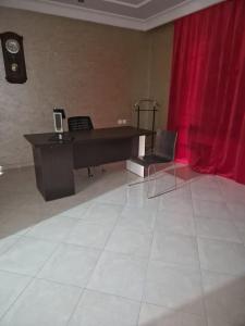 een piano in een kamer met een rood gordijn bij centre d'affaire in Zemmour Touirza
