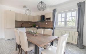 - une cuisine avec une table en bois et des chaises blanches dans l'établissement Amazing Apartment In Kasic With Wifi, à Kašić