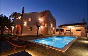- une piscine en face d'une maison la nuit dans l'établissement Amazing Apartment In Kasic With Wifi, à Kašić
