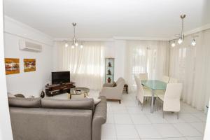 een woonkamer met een bank en een tafel bij The Royal Links two bedroom apartment in Ortaca
