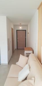 a living room with a white couch and a table at L'albizia Studio calme et tout confort in Lucciana