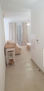 a white living room with a couch and a table at L'albizia Studio calme et tout confort in Lucciana