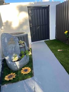 a statue sitting in the grass next to a door at Charming 2-Room Oasis - Miami in Tamiami