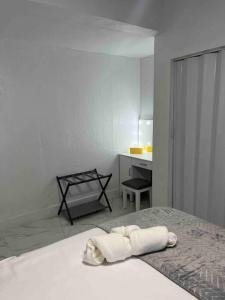 Un dormitorio blanco con una cama con una toalla. en Charming 2-Room Oasis - Miami en Tamiami