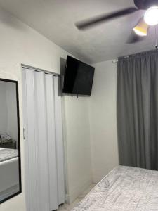 a bedroom with a bed and a television on the ceiling at Charming 2-Room Oasis - Miami in Tamiami