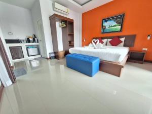 a bedroom with a large bed with an orange wall at Lanta noblesse in Ko Lanta