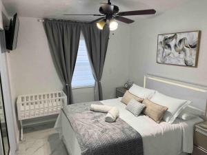 a bedroom with a bed with a ceiling fan at Charming 2-Room Oasis - Miami in Tamiami