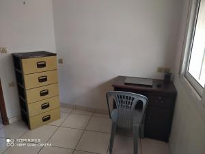 a desk and a chair next to a dresser at Chambre dans un appartement ensoleillé in Tangier