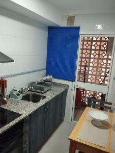 a kitchen with a sink and a blue window at Piso encantador Mediterráneo in Rincón de la Victoria