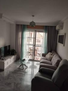 a living room with a couch and a television at Piso encantador Mediterráneo in Rincón de la Victoria