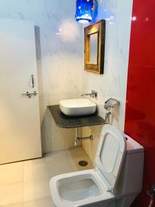 uma casa de banho com um lavatório branco e um WC. em Swiss House em Jodhpur