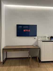 a table in a kitchen with a television on the wall at Pristina Select Apartments in Prishtinë