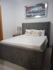 a bedroom with a large bed with love pillows at El mejor apartamento cerca de la playa de Boca Chica in Boca Chica