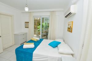 a bedroom with a bed with blue and white sheets at The Royal Links two bedroom apartment in Ortaca