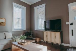 a living room with a couch and a flat screen tv at 1900's Historic Lancaster School House in Willow Street