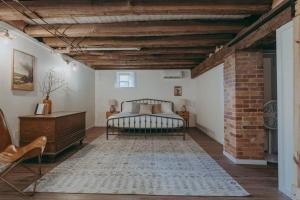 a bedroom with a bed and a brick wall at 1900's Historic Lancaster School House in Willow Street