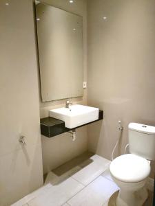 een badkamer met een wit toilet en een wastafel bij Indraprastha Residence in Seminyak