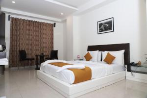 a bedroom with a large bed and a desk at Hotel Sai Bansi in Shirdi