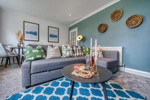 uma sala de estar com um sofá e uma mesa em 2 Bed Stylish Spacious Apt -Sleeps 6 Central Cheltenham, with Free Parking - By Blue Puffin Stays em Cheltenham