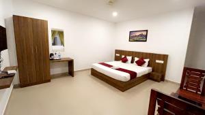a bedroom with a bed with red pillows at Hotel Dream Suite, Kattappana in Kattappana