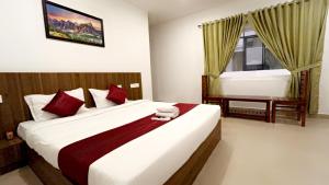 a bedroom with two beds and a window at Hotel Dream Suite, Kattappana in Kattappana