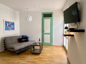 een woonkamer met een bank en een flatscreen-tv bij Ferienhaus am Wald in Gotha