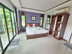 1 dormitorio con cama blanca y almohadas rojas en Lanta noblesse en Ko Lanta