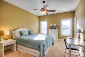 a bedroom with a bed and a desk and a ceiling fan at Luxury Townhouse w/ Golf Cart & Private Elevator in Carolina Beach