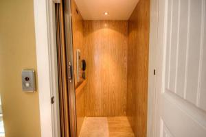 a bathroom with a shower with a wooden wall at Luxury Townhouse w/ Golf Cart & Private Elevator in Carolina Beach