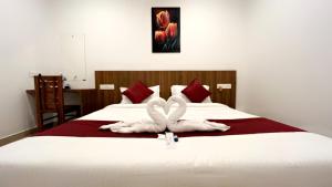 a bedroom with two swans towels on a bed at Hotel Dream Suite, Kattappana in Kattappana