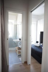 a bedroom with a bed and a bathroom with a mirror at Ostia Sunset in Lido di Ostia